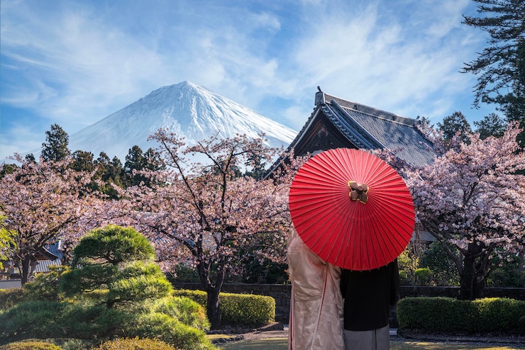 Foto casal de viajantes de quimono e guarda-chuva na mão reflexão fuji yama vulcão mountain em japonês antigo