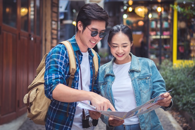 Foto casal de viajantes usando o mapa para passeios na cidade