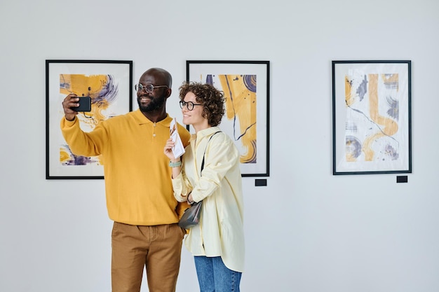 Casal de visitantes tomando selfie na galeria