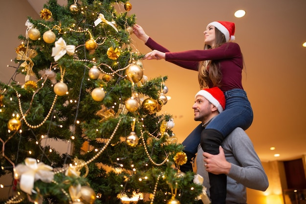 Casal decorando a árvore de natal