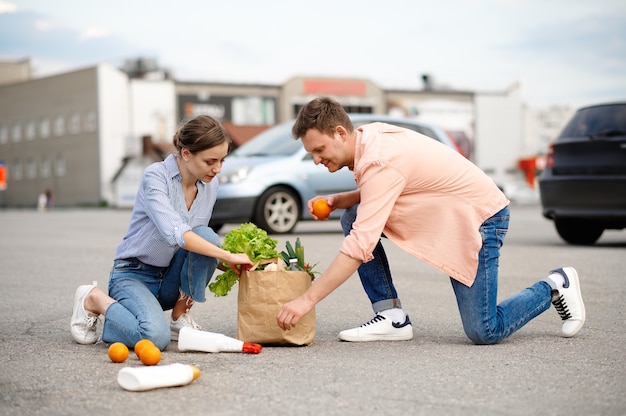 Casal deixou cair o pacote no estacionamento do supermercado