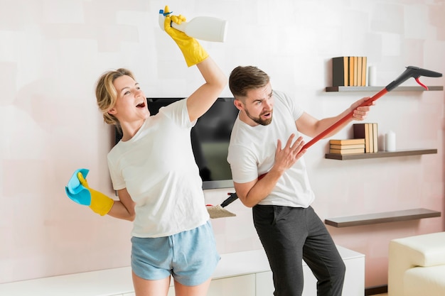 Foto casal dentro de casa pronto para limpar a casa