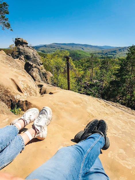 Casal descansando no topo da rocha com bela paisagem vista caminhada conceito