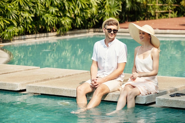 Casal descansando perto da piscina