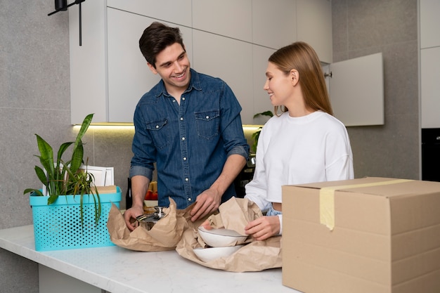 Foto casal desempacotando seus pertences depois de se mudar para uma nova casa