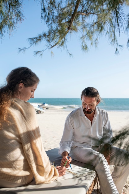 Foto casal desenhando na praia durante as férias