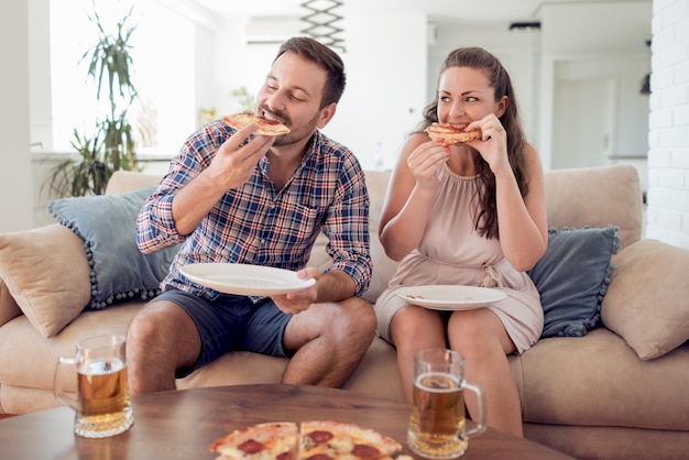 Casal desfrutando de algumas bebidas e pizza