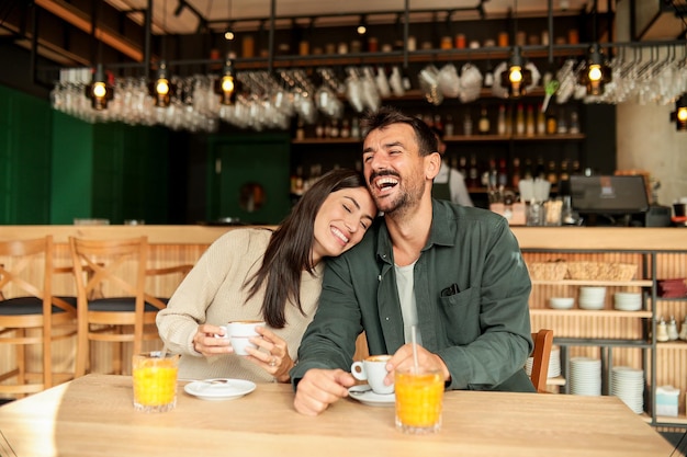 Casal desfrutando em um café aconchegante com bebidas quentes e risadas em um ambiente moderno vibrante em uma tarde ensolarada