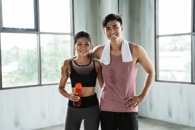 Casal desportivo mãos na cintura na sala de ginástica