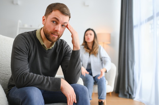 Casal discutindo Mulher gritando para seu marido desesperado sentado em um sofá na sala de estar em casa