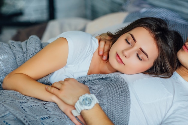 Casal dormindo em cama confortável, garota deitada com seu homem