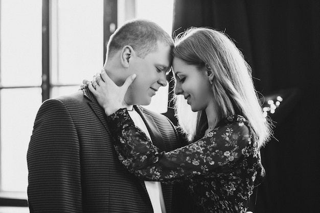 Casal elegante tocando cara a cara, com os olhos fechados