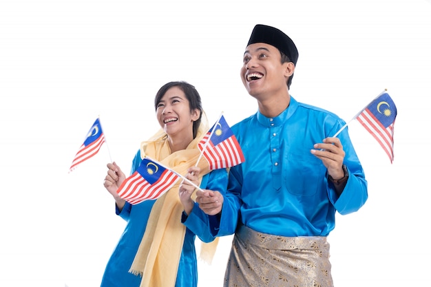 Casal em azul segurando a bandeira da Malásia