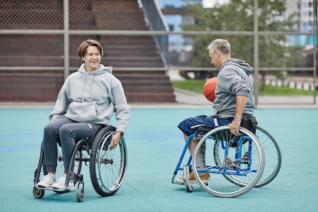 Casal em cadeira de rodas jogando basquete