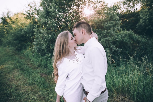 Casal em campo ao pôr do sol