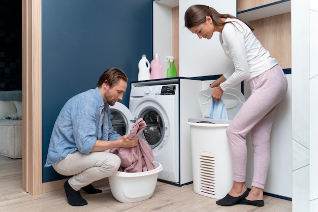 Casal em casa fazendo tarefas domésticas