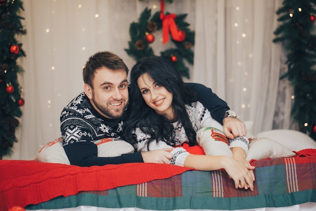 Casal em roupas de inverno, abraçando as luzes