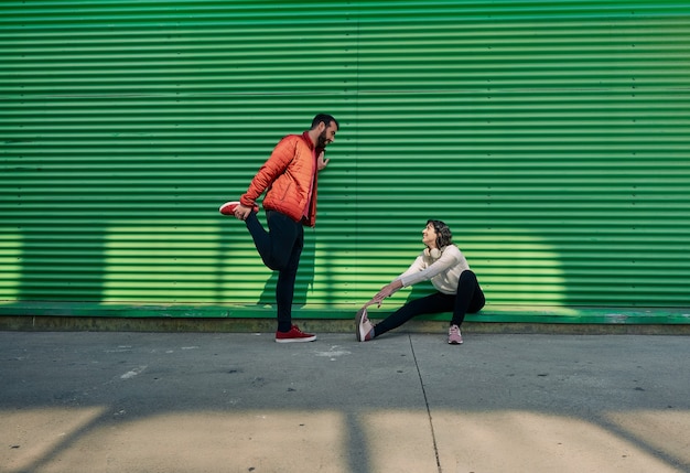 Casal em roupas esportivas conversando enquanto pratica esportes