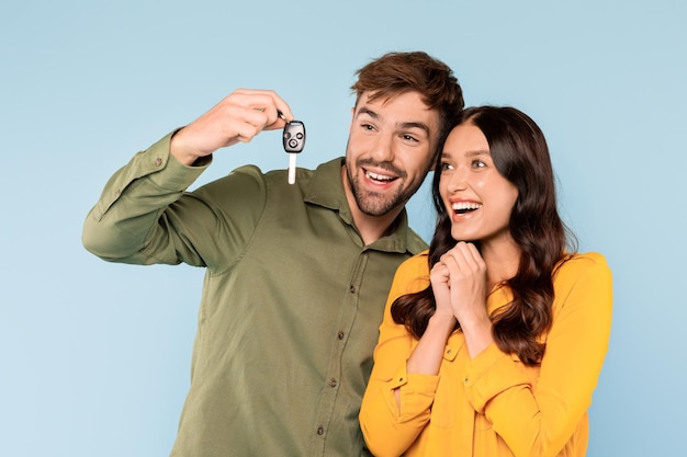 Foto casal entusiasmado com a chave do carro novo comemora a compra alegre