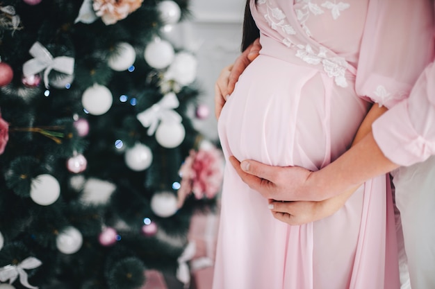 Foto casal esperando um bebê no contexto da árvore de natal