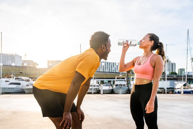 Casal esportivo multiétnico treinando ao ar livre