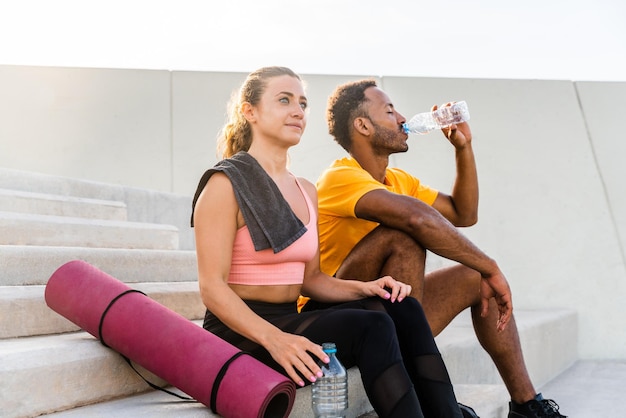 Foto casal esportivo multiétnico treinando ao ar livre