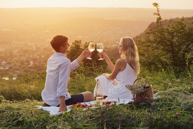 casal está brindando copos com vinho e sorrindo