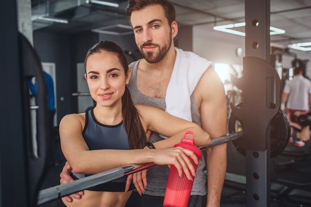 Casal está de pé juntos na sala de treinamento e posando na câmera