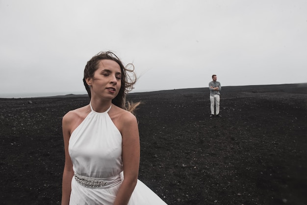 Foto casal está de pé perto do avião que caiu há muito tempo na praia negra