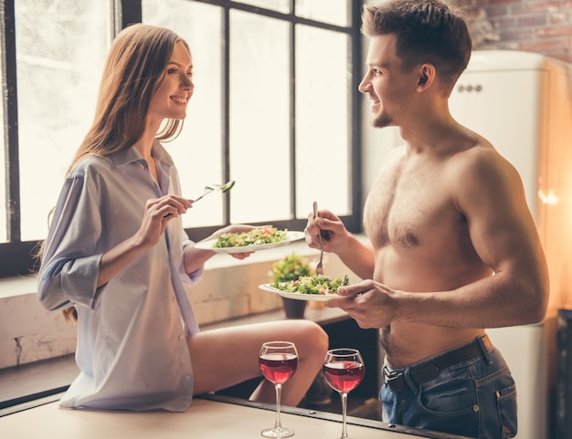 Casal está falando e sorrindo enquanto toma um jantar romântico