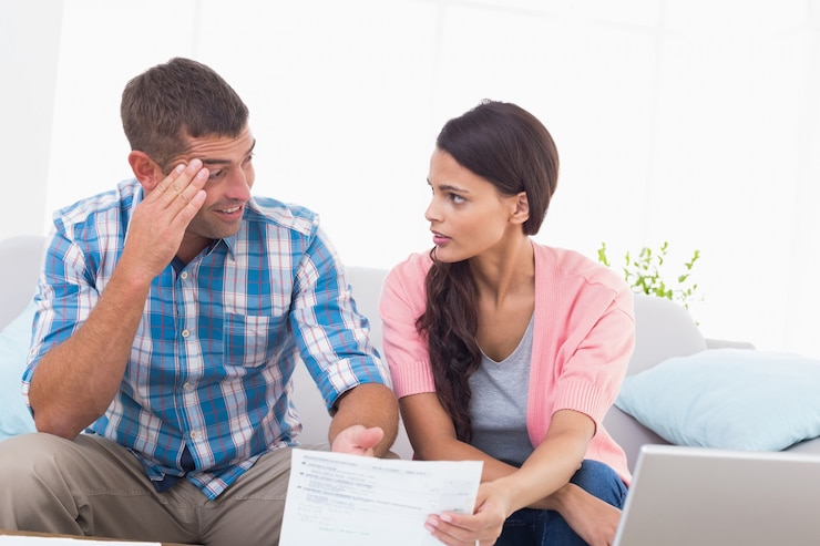Foto casal estressado discutindo sobre as finanças domésticas