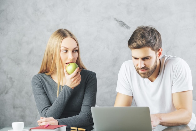 Casal europeu na mesa com laptop