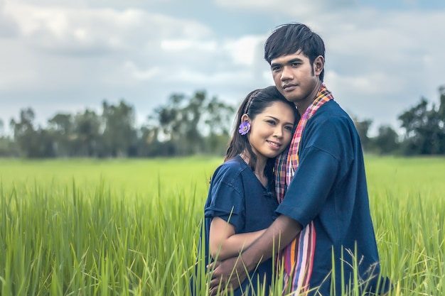 Casal fazendeiro em terno de agricultor com campos de arroz