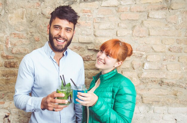 Casal fazendo torradas com cocktails