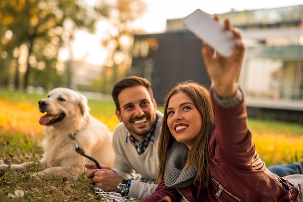 Casal fazendo uma selfie com seu cachorro