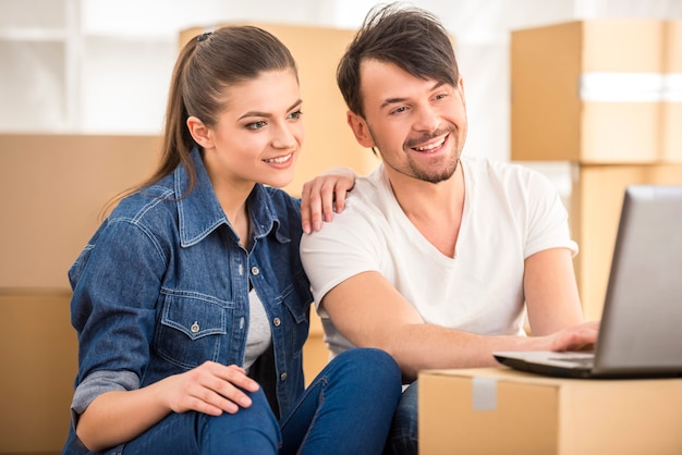 Casal feliz à procura de apartamentos com laptop.