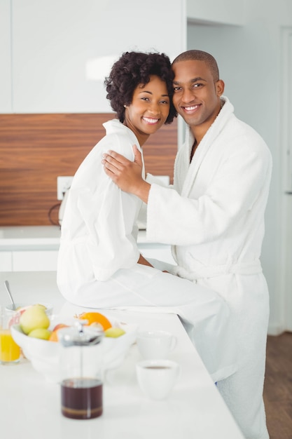 Casal feliz abraçando na cozinha em casa