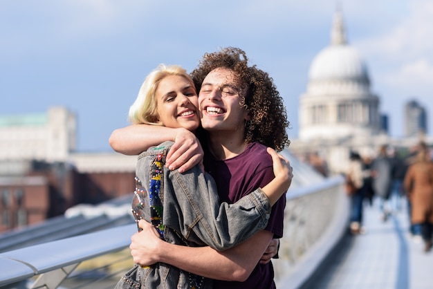 Casal feliz abraçando pela ponte do milênio, rio tamisa, londres.