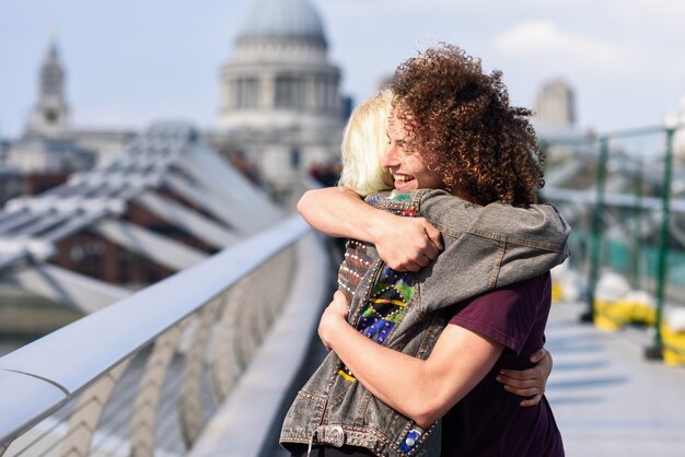 Casal feliz abraçando pela ponte do milênio, rio tamisa, londres.