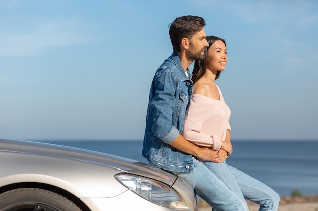 Casal feliz abraçando-se cabriolet inclinado