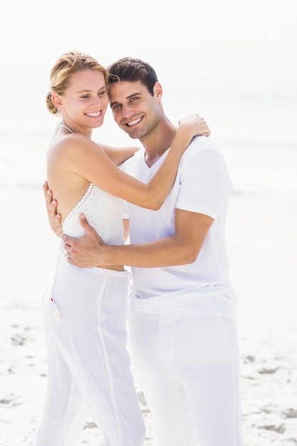 Casal feliz, abraçando-se na praia