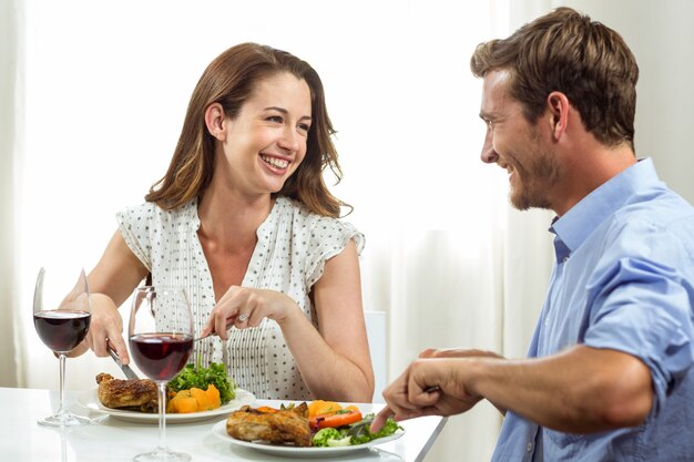 Casal feliz almoçando em casa