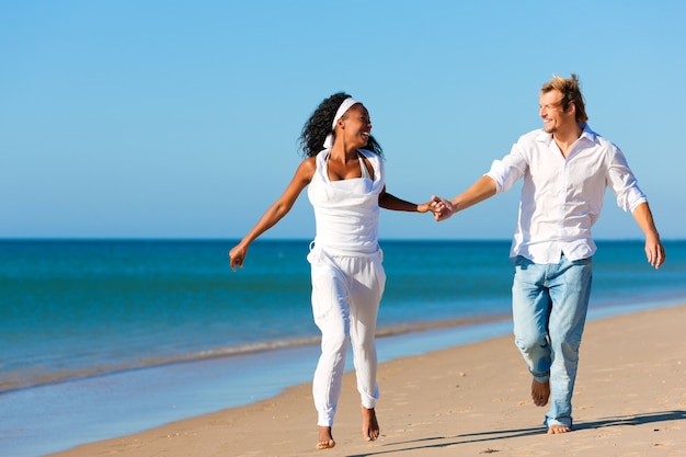 Casal feliz andando e correndo na praia