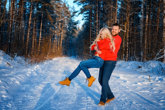 Casal feliz andando na floresta de neve