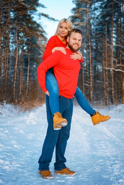 Casal feliz andando na floresta de neve