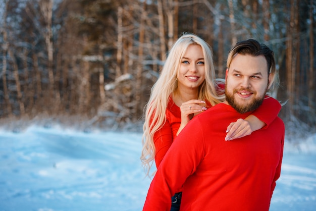 Casal feliz andando na floresta de neve