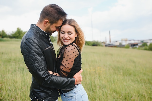 Casal feliz apaixonado ao pôr do sol e sorrindo