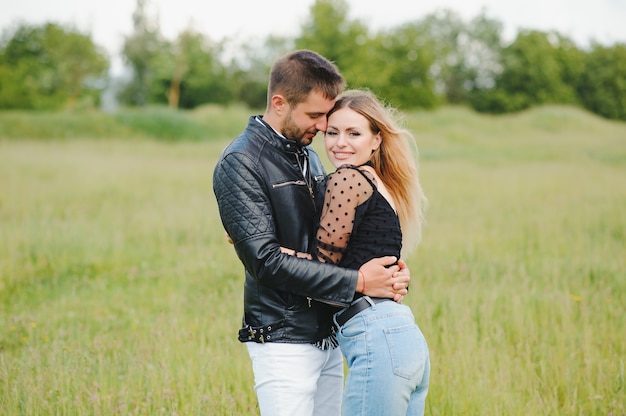 Casal feliz apaixonado ao pôr do sol e sorrindo