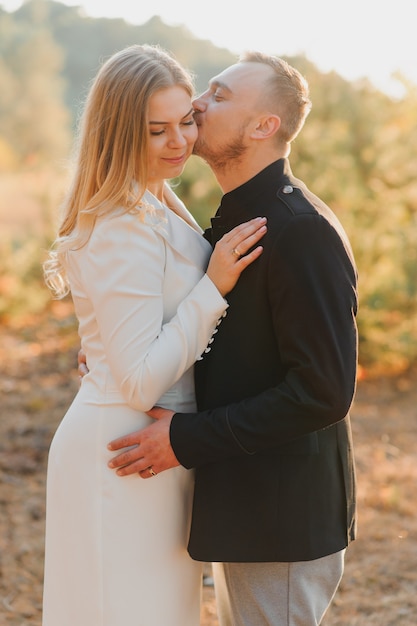 Casal feliz apaixonado ao pôr do sol e sorrindo