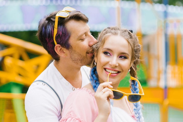 Casal feliz apaixonado beijando em um parque de diversões ao ar livre durante o tempo de lazer conceito de estilo de vida dos jovens